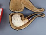 a pipe in a case and a pipe holder on a table
