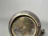a close up of a silver cup sitting on top of a table