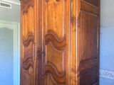 a large wooden armoire in the corner of a room