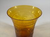 a yellow glass bowl sitting on a white surface