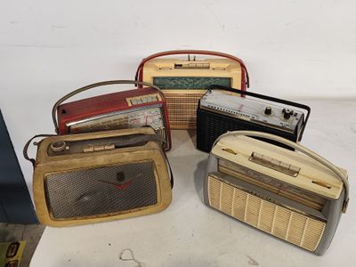 de nombreux modèles différents de vieilles radios posées sur une table