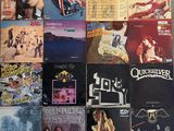 many different album covers on the wall of a room