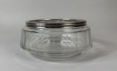 a glass jar with a silver lid on a white surface