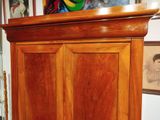 a wooden cabinet with a painting on the top of it