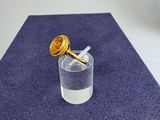 a glass of water with a gold knob on it
