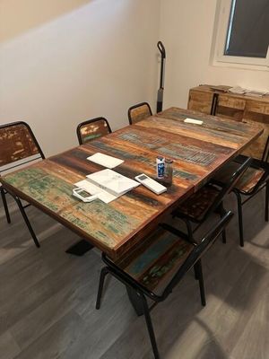 une table et des chaises en bois dans une pièce dotée d'une fenêtre
