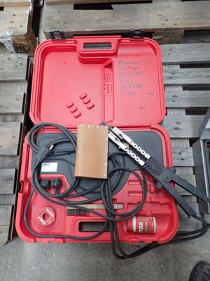 une caisse rouge contenant des outils, posée sur une palette