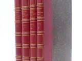 trois livres rouges superposés sur une surface blanche