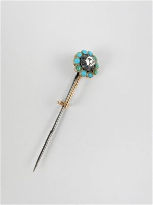 un gros plan d'une broche en métal ornée d'une fleur
