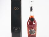 the bottle of brandy is next to the box on the table