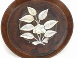 a wooden plate with a white flower on it