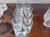 bottles and glasses on a wooden table with a stencil on the wall