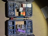 two black boxes with tools in them on the floor