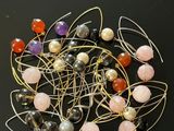 de nombreuses perles de différentes couleurs et du fil métallique sur un fond noir
