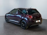 the back of a purple car in a room with a white wall