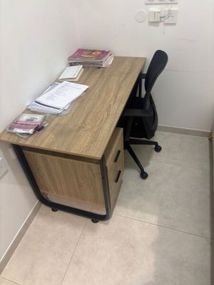 un bureau avec une chaise et un ordinateur posé dessus, dans une petite pièce