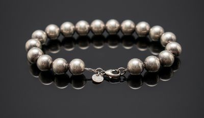 un bracelet orné de perles argentées sur un fond noir
