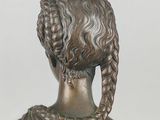 bronze statue of a woman with braided hair and braids on her head