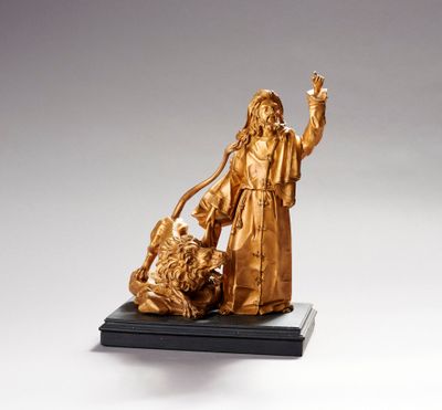 statue représentant un homme tenant un chien et un lion, posée sur un socle