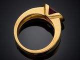 a gold ring with a red stone in the middle