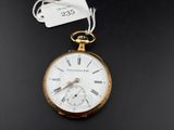 une vieille montre de poche à laquelle est attachée une étiquette, posée sur une surface noire