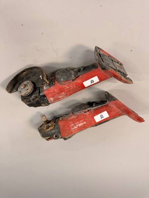 une paire de vieilles lances à incendie rouges et noires posées sur une surface blanche