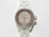 une montre blanche ornée de cristaux violets, posée sur un fond blanc
