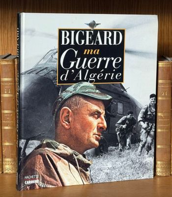 un livre posé sur une étagère à côté d'une pile de livres