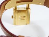 a close up of a gold watch with a brown leather strap