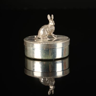 a silver rabbit sitting on top of a silver box