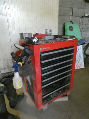 une boîte à outils rouge sur laquelle sont posés des outils, dans un garage