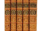 six vieux livres sont alignés sur une surface blanche