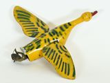 a yellow and green bird shaped object on a white surface
