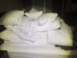 a pile of pillows on top of a bed