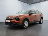 une voiture marron garée dans une pièce aux murs blancs