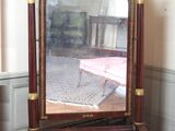 un miroir posé sur un pied dans un coin de la pièce