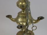 brass oil lamp with a chain hanging from it ' s neck