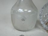 a glass vase and a clock sitting on a table