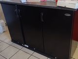 un petit réfrigérateur noir dans un coin de la pièce
