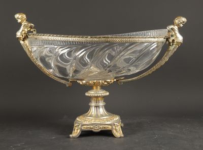 un bol ancien en argent et en verre posé sur un socle, sur fond noir