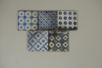 Cinq carreaux en faïence à décor de fleurettes bleues, porta…