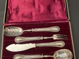 an assortment of silverware in a velvet case on a table