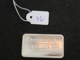 a metal tag with a name on it on a black surface