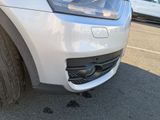 a close up of the front bumper of a white car