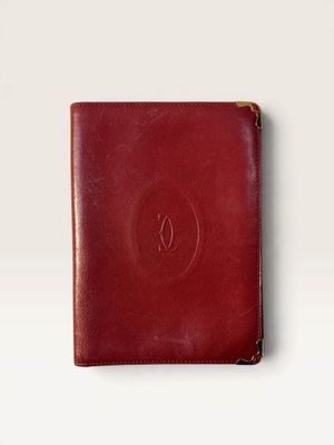 a red leather passport case sitting on top of a white surface
