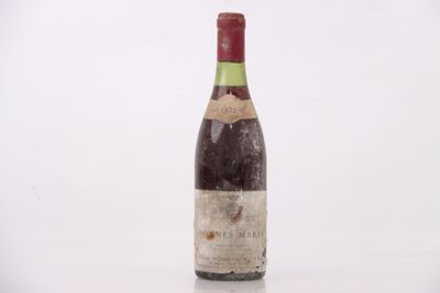 une vieille bouteille de vin posée sur une surface blanche