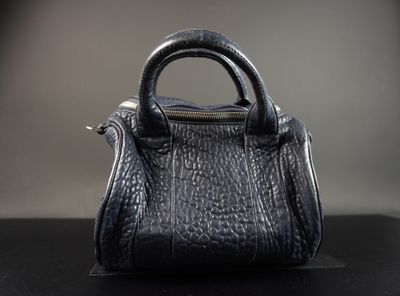 une photo d'un petit sac à main noir posé sur une table