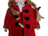 poupée vêtue d'un manteau rouge et d'un chapeau, aux longs cheveux blonds et aux yeux bleus