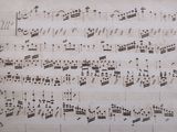 an old manuscript with music notes on it and a cross in the middle