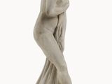 une statue représentant une femme en robe blanche posée sur un socle blanc